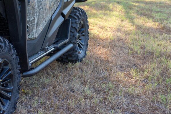 The front end of an atv is parked in a grassy area.