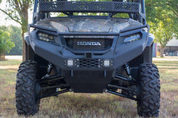 The front end of a utv in a grassy field.