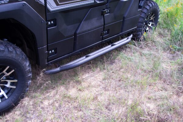 A black hummer h2 side steps are parked in a grassy area.